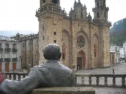 Statue eines Mannes von hinten im Vordergrund mit der Kathedrale im Hintergrund.