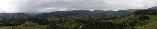 Panorámica del valle con colinas verdes y árboles.