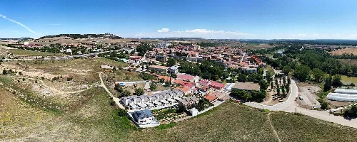 Vista panorámica de Simancas desde el sur con edificios y campo.