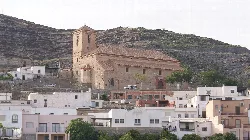 Church of Gérgal amidst white houses and hills.