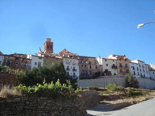 Häuser und eine Kirche in einem Dorf mit blauem Himmel.