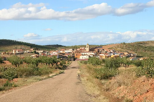 Panoramic view of Alarba with houses, church, and rural landscape.