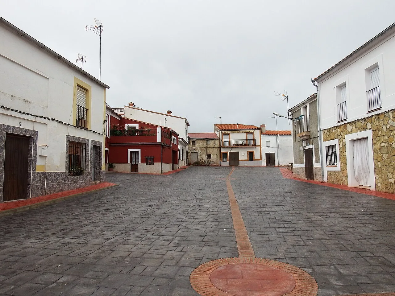 View of the square with white houses and gray sky in La Aldea del Obispo.