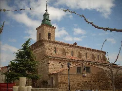 Stone church with tower and red tiled roof in Fuentes Claras.
