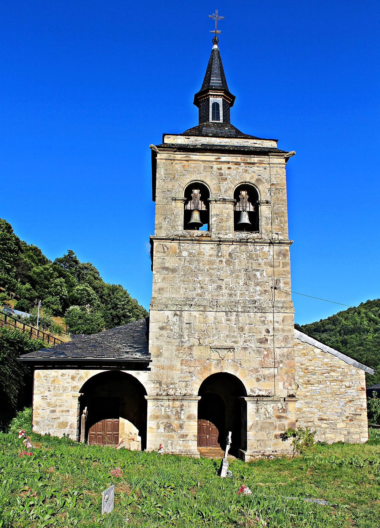 Stone church with bell tower and pointed roof in Barjas, León