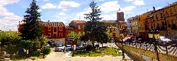 Square with trees, benches, and buildings in Osorno la Mayor.