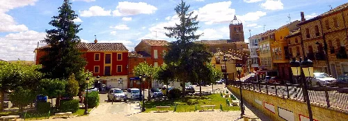 Square with trees, benches, and buildings in Osorno la Mayor.