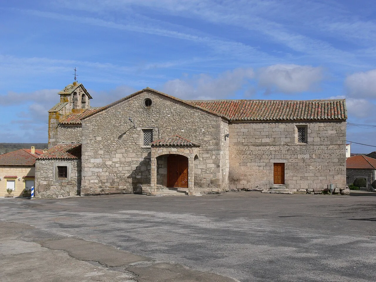 Steinkirche in Cipérez mit Turm und Holztür.