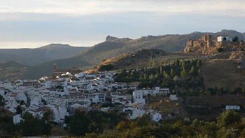 Landschaft von Carcabuey mit weißen Häusern und Burg auf dem Hügel.