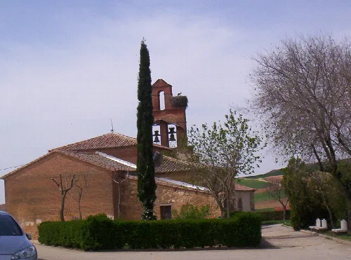 Kirche St. Johannes der Täufer mit Glockenturm und Bäumen in Gallegos del Pan.