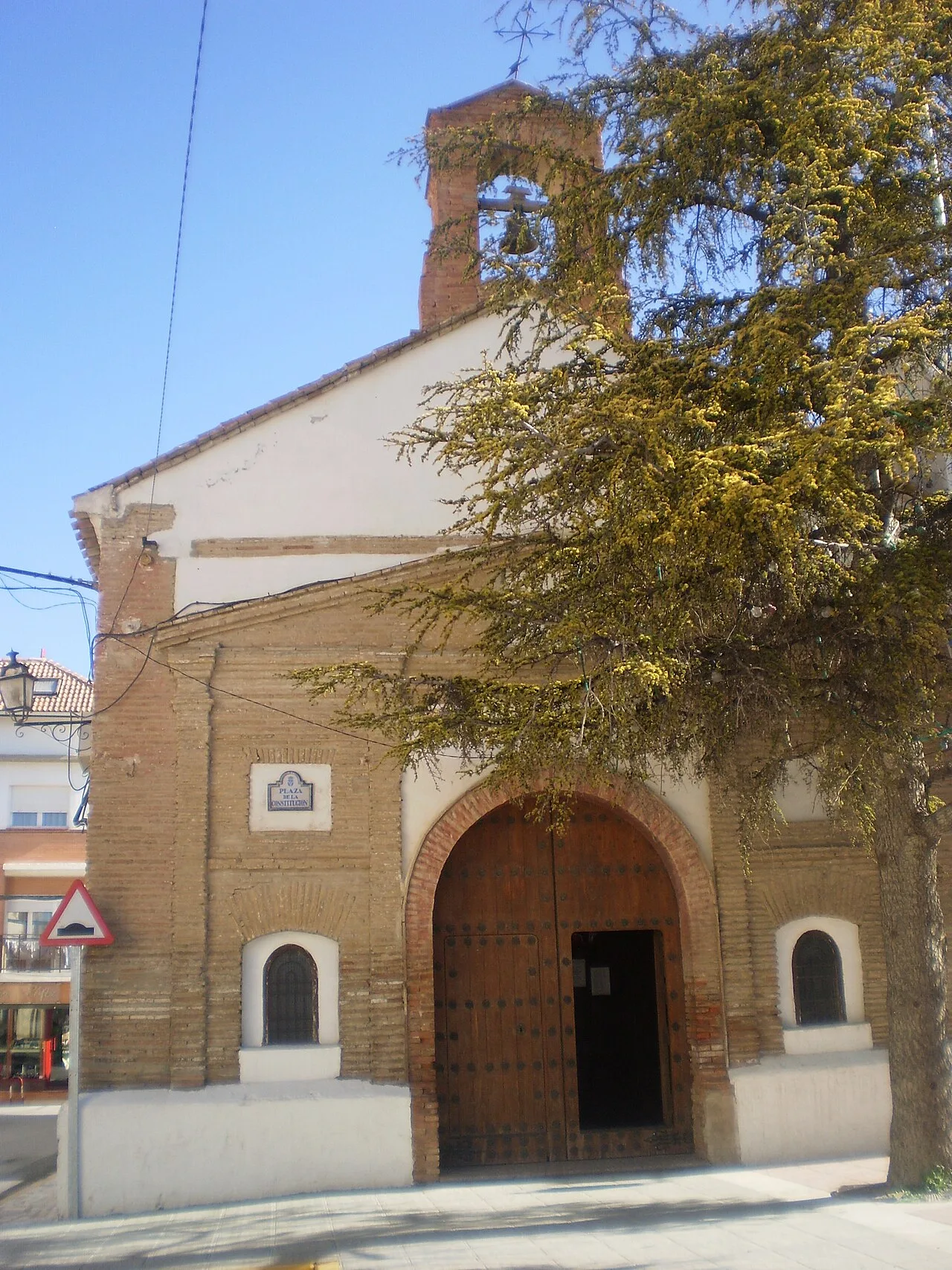 Kapelle San Sebastián in Caniles mit Holztür und Glockenturm.