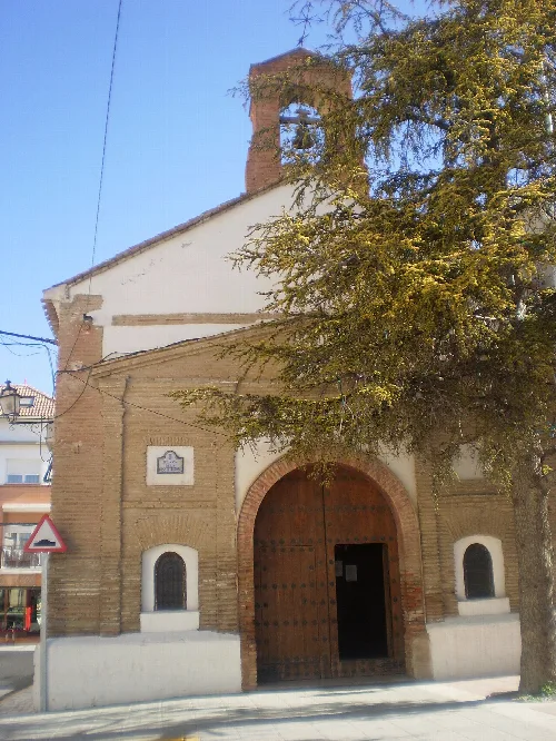 Kapelle San Sebastián in Caniles mit Holztür und Glockenturm.