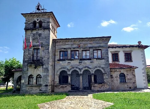 Edificio del ayuntamiento con torre y fachada de piedra en Santa María de Cayón.