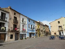 Calles con casas de colores y mesas en la plaza de El Toro.