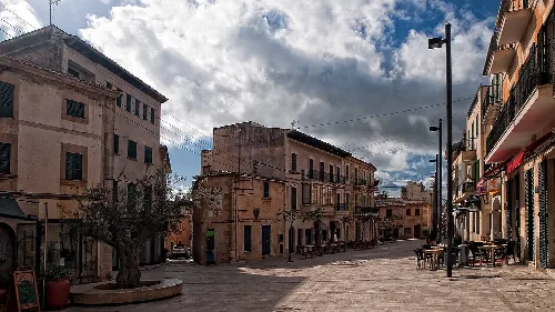 Plaza Mayor in Santañí mit alten Gebäuden und bewölktem Himmel.