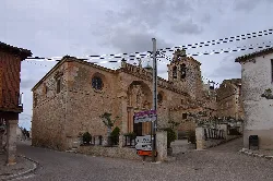 San Miguel Árcangel church in Fuentelcésped with bell tower and stone facade.