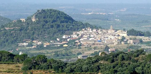 Vista panorámica de Marçà con colinas y pueblo en el valle.