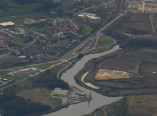 Imagen aérea de un río, puerto y viviendas en Requejada, Cantabria.