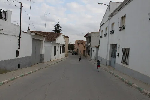 Ansicht einer Straße mit weißen Häusern und spielenden Kindern in Villalpardo.