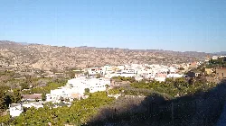Panoramic view of Instinción with white houses and mountains.