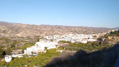Panorámica de Instinción con casas blancas y montañas.