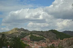 Landscape with mountains, houses, and cloudy sky in Montalbán.