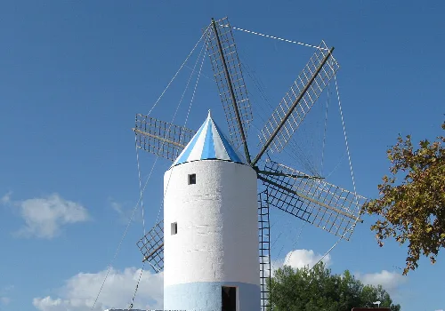 Weiße Windmühle mit Holzflügeln in San Luis, Menorca.