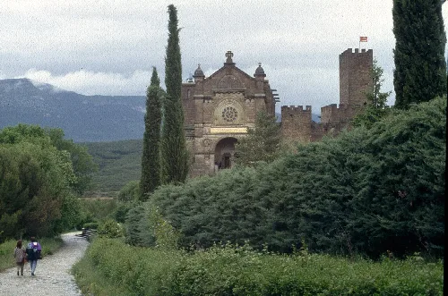 Church and castle in Javier with trees and a path in the foreground.