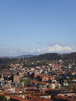 Paisaje urbano de Berango visto desde Algorta con colinas y cielo azul.