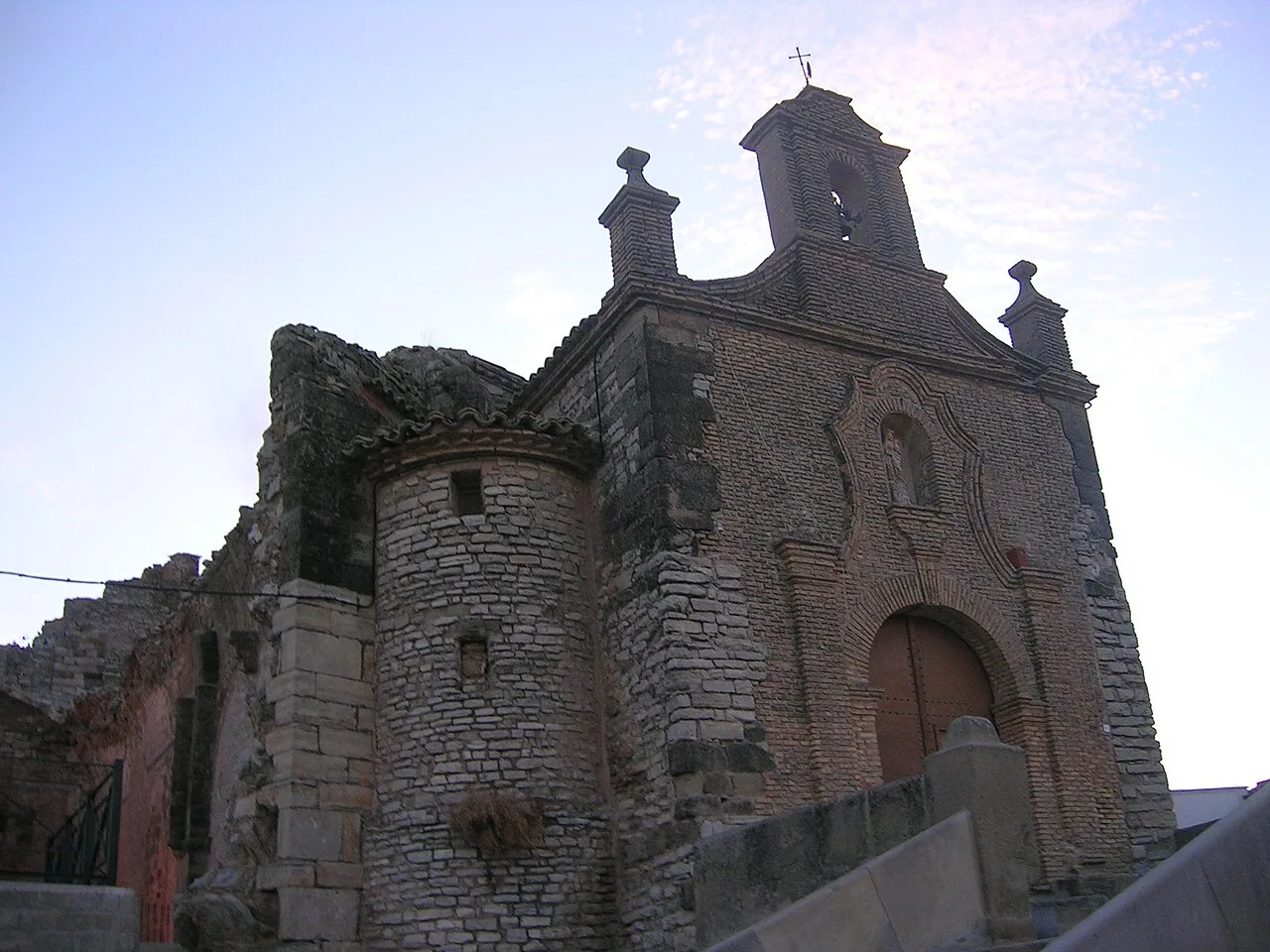 Stone hermitage with tower and cross in Almudévar.