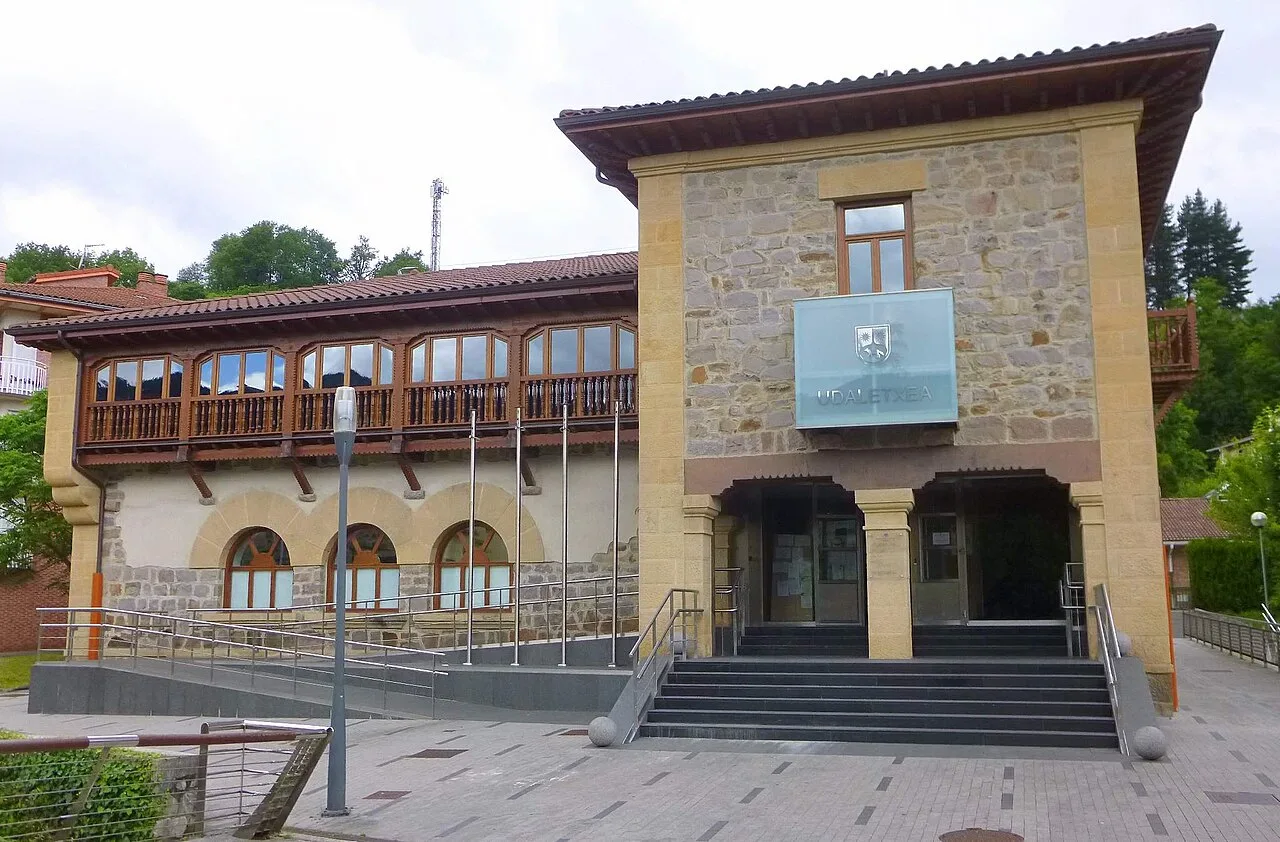 Edificio del ayuntamiento con fachada de piedra y balcón de madera en Idiazábal.