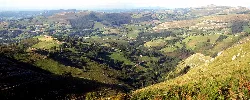 Paisaje de montañas y campos verdes en Riotuerto desde La Linde.