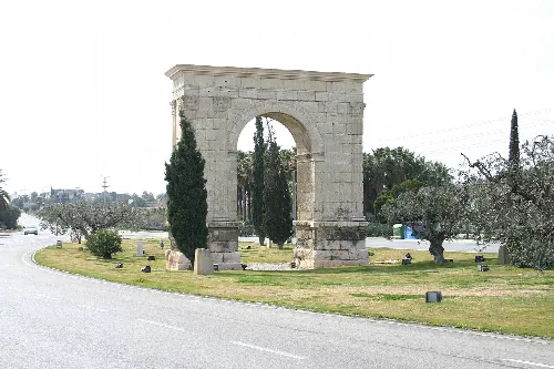 Bogen von Berà in Roda de Bará, Tarragona, mit Bäumen und Straße in der Nähe.