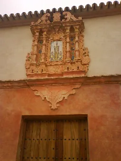 Fachada con detalles en madera tallada y pintura en la Cilla del Cabildo en Sanlúcar la Mayor.