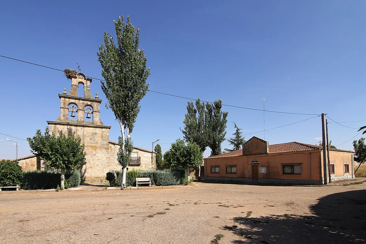 Square with trees, church, and building in Carrascal de Barregas.