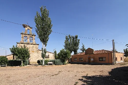 Square with trees, church, and building in Carrascal de Barregas.