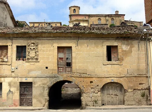 Edificio de piedra con arco y escudo en Treviana, La Rioja.