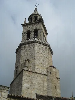 Stone church tower with bell tower and dome in Pedroche.