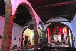 Interior of a church with arches and decorated altar in Garafía.