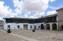 Local museum building in a square with planters and cloudy sky.