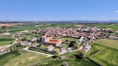 Aerial view of the town with churches and green fields around.