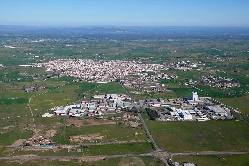 Vista aérea de Pozoblanco con ciudad y zonas industriales en un paisaje rural.