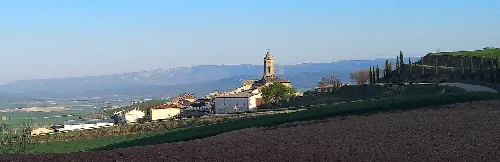 Landscape of Olejua with church on the hill and green fields.