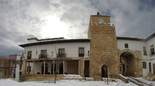 Rathaus von Iniesta mit Schnee und bewölktem Himmel.