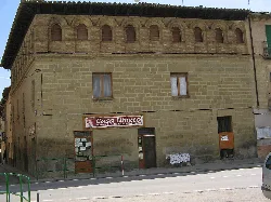 Stone building façade with a brick arch gallery at the top.