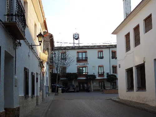 Platz mit weißen Gebäuden und Uhr in Casas de Benítez.