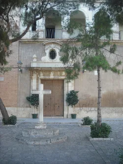 Facade of Rocafort church with cross and trees in front.