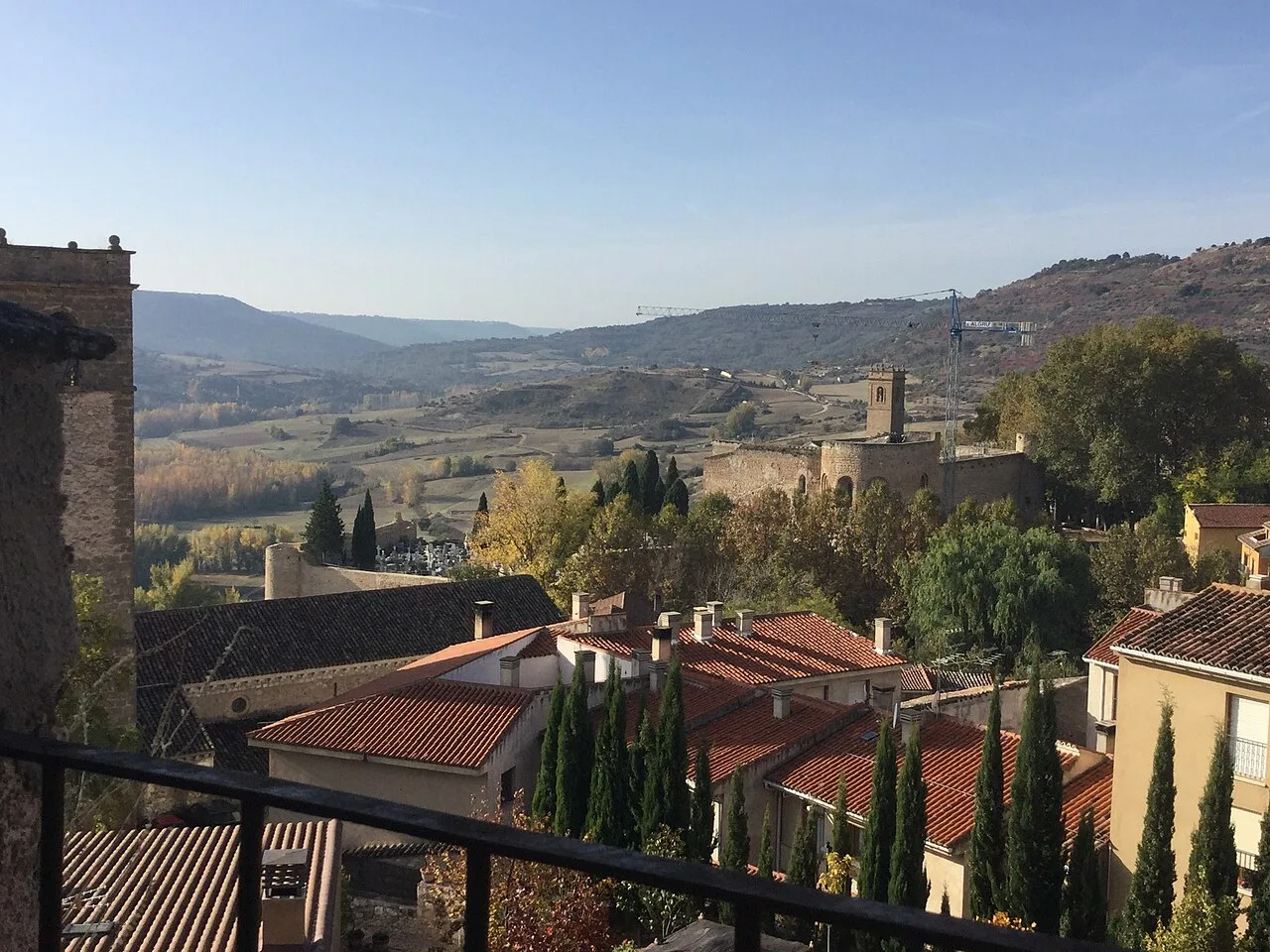 Landscape of Brihuega with houses, trees, and hills in the distance.