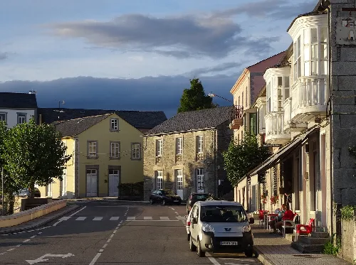 Straße mit alten Häusern und einem geparkten Auto in Baleira.
