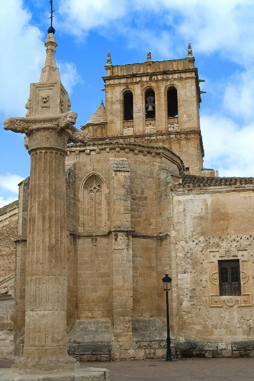 Old church and column in Vadocondes, Burgos, with blue sky.